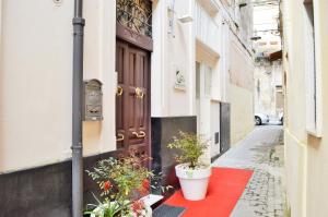 uma porta com dois vasos de plantas sobre um tapete vermelho em Casa34 em Ragusa