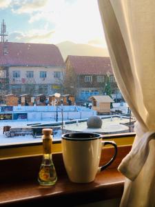 une tasse de café assise sur un rebord de fenêtre avec vue dans l'établissement CENTRAL Kolašin, à Kolašin