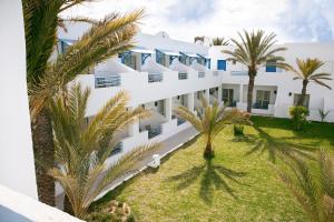 een uitzicht op een gebouw met palmbomen bij ROBINSON DJERBA BAHIYA - All Inclusive in Midoun