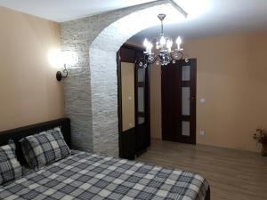 a bedroom with a bed and a stone wall at Meny Apartaments in Codlea