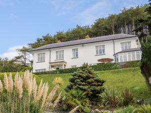 a white house on a hill with a garden at Brynmorwydd in Aberdyfi