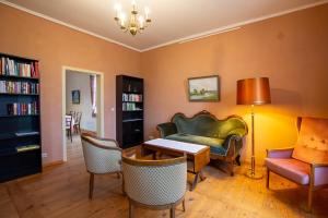 a living room with a couch and a table and chairs at Altes Pastorat Schwichtenberg in Borrentin