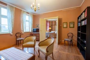 a living room with two chairs and a bed at Altes Pastorat Schwichtenberg in Borrentin