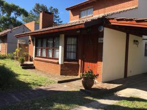 a house with a porch and a flower pot in front of it at Chalet en Villa Gesell in Villa Gesell