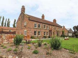 an old brick house with a garden in front of it at Copmanthorpe Hall in York
