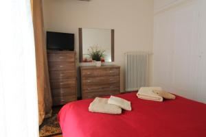 アテネにあるSea and City Apartmentのベッドルーム1室(赤いベッド1台、ドレッサー、鏡付)