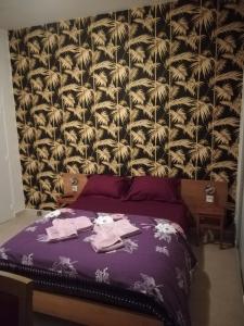 - une chambre avec un lit violet et un papier peint floral dans l'établissement Résidence Pearl, à Nice