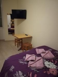 a bedroom with a bed with purple sheets and a table at Résidence Pearl in Nice