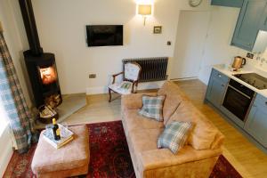 a living room with a couch and a stove at Knotts Rest in Skipton