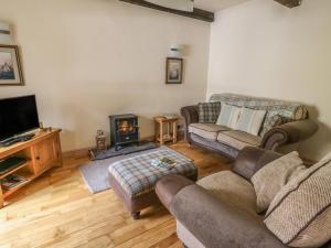 a living room with two couches and a fireplace at Hedgehog Cottage in Settle