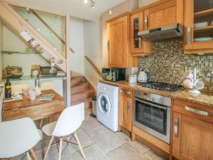 a kitchen with a stove and a washer and dryer at Hedgehog Cottage in Settle