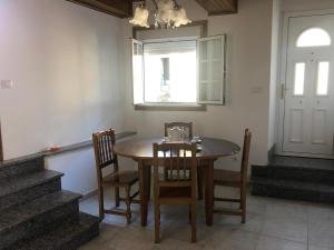 comedor con mesa, sillas y ventana en A Casa do Chico, en Ourense