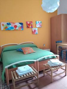 una camera con un letto verde con due tavoli di B&B SoleLuna della Solidarietà a Palermo