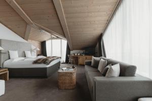 1 dormitorio con 1 cama y 1 sofá en Eco & Wellness Boutique Hotel Sonne, en Livigno