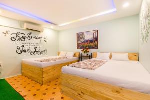 a bedroom with two beds and a painting on the wall at Ben Thanh Dorm in Ho Chi Minh City