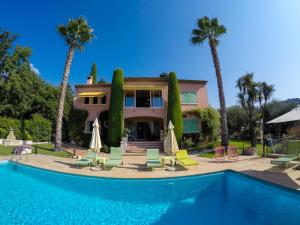 a house with a swimming pool and palm trees at Mas Du Roc Bed & Breakfast in Grasse