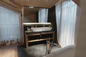 Eco & Wellness Boutique Hotel Sonne في ليفينو: حمام مع حوض ومرآة