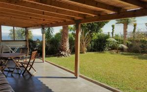 カニコにあるAtlantic Palm Garden Residenceの木製パーゴラの下にテーブルと椅子が備わるパティオ