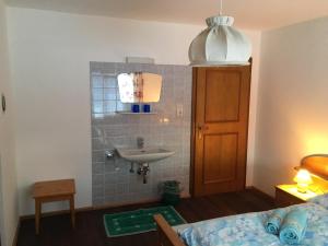 a small bathroom with a sink and a bed at Mitterhaidgut in Hollersbach im Pinzgau