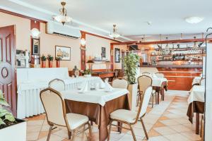 a restaurant with tables and chairs and a bar at Cumulus Hotel in Będzin