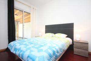 ein Schlafzimmer mit einem großen Bett und einem Fenster in der Unterkunft Atlantic Palm Garden Residence in Caniço