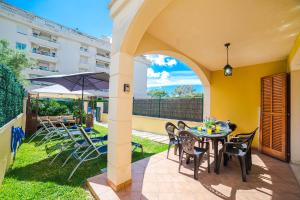 een patio met een tafel en stoelen en een parasol bij Villa Alcudia Cycling in Alcudia