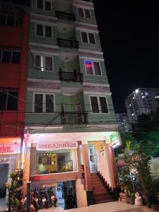 Ein Gebäude mit Leuten, die vor einem Laden sitzen in der Unterkunft Cát tường 2 hotel in Ho-Chi-Minh-Stadt