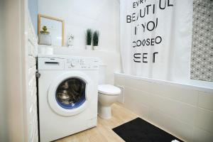 een badkamer met een wasmachine en een toilet bij British Quarter Studios in Kiev