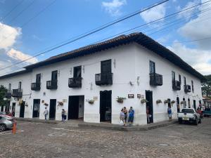 a white building with people standing outside of it at Hotel Las Nieves in Girón