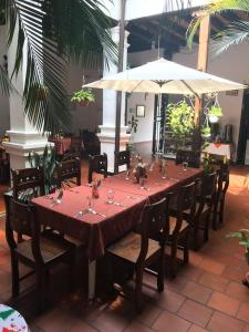 a long table with chairs and an umbrella at Hotel Las Nieves in Girón