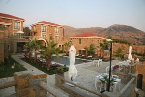 a pool with tables and umbrellas next to some buildings at Anemos Hotel in Gokceada Town