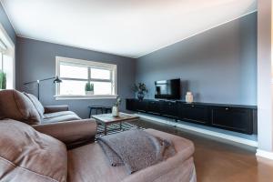 a living room with a couch and a tv at GreenKey House B16 in Keflavík