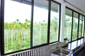 a kitchen with four windows and a kitchen sink at Chamayam Holiday Villa in Meenangadi