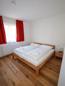 un grande letto in una stanza con finestra rossa di Appartementhaus Römerhof Superior a Bad Kleinkirchheim