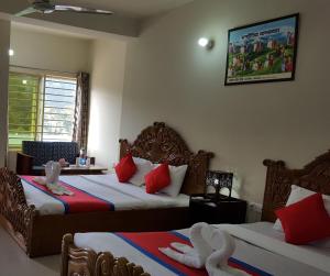 a hotel room with two beds with red pillows at Hotel Hill View in Bāndarban