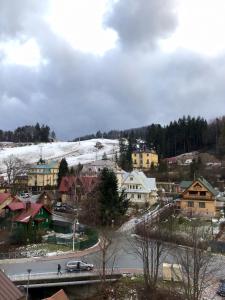 a town with a snow covered hill with houses at Apartament Karpaty in Krynica Zdrój