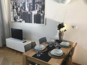 a dining room with a table with chairs and a television at Apartment Náměstí Bratří Synků in Prague