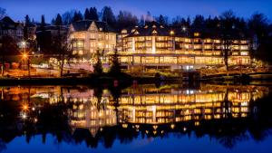 un grand bâtiment avec des lumières sur l'eau la nuit dans l'établissement Romantischer Winkel RoLigio & Wellness Resort, à Bad Sachsa