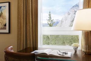 a desk with a book and a window at Fairmont Banff Springs in Banff
