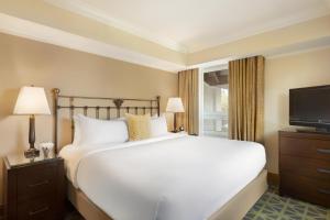 a bedroom with a white bed and a flat screen tv at Fairmont Banff Springs in Banff