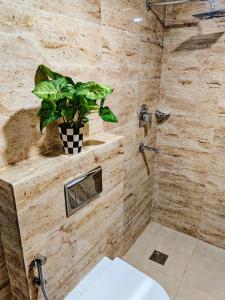 a bathroom with a plant on a stone wall at Bandipur Village Inn in Bandipur