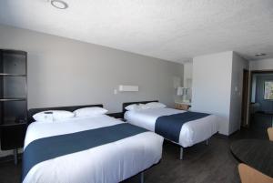 a hotel room with two beds and a television at Motel 6-Saanichton, BC - Victoria Airport in Saanichton