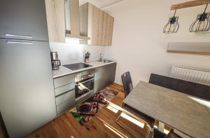 una cucina con tavolo, lavandino e frigorifero di Appartementhaus Römerhof Superior a Bad Kleinkirchheim