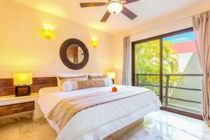 a bedroom with a bed and a large window at Maya Villa Condo Hotel and Beachclub in Playa del Carmen