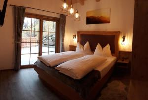 a bedroom with a large bed with a large window at Maurachhof in Grossarl