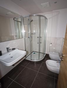 a bathroom with a shower and a sink and a toilet at Appartements Römerhof Superior - Kärnten Card im Sommer inklusive in Bad Kleinkirchheim