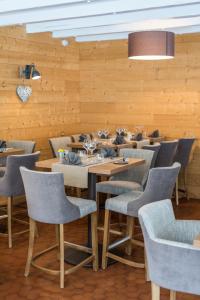 a restaurant with wooden walls and tables and chairs at Le Relais du Galibier in Valloire
