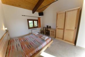 a bedroom with a bed and a desk in it at Casale Dei Mattonari in Giano dellʼUmbria