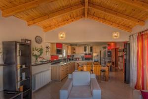 a large kitchen with wooden ceilings and a dining room at Elisavet Apts in Kavos
