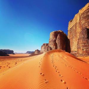 a desert with rocks and footprints in the sand at Wadi rum desert breath in Wadi Rum